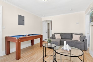 A room with a pool table, a sofa, and a glass coffee table. - Huge Home Near Downtown Boston! Bow Market, Harvard, MIT, Union Square! (Somerville)