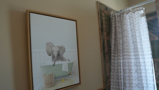 Ein gerahmtes Bild von einem Elefanten in einem Badezimmer.