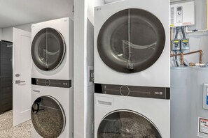 Eine Reihe von weißen Waschmaschinen mit Bedienfeldern und einem Warmwasserbereiter.