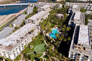 Ein Resort mit mehreren Gebäuden, einem Schwimmbad und einer Brücke im Hintergrund.