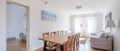 En rummelig opholdsstue med et træbord, en sofa og en lampe.