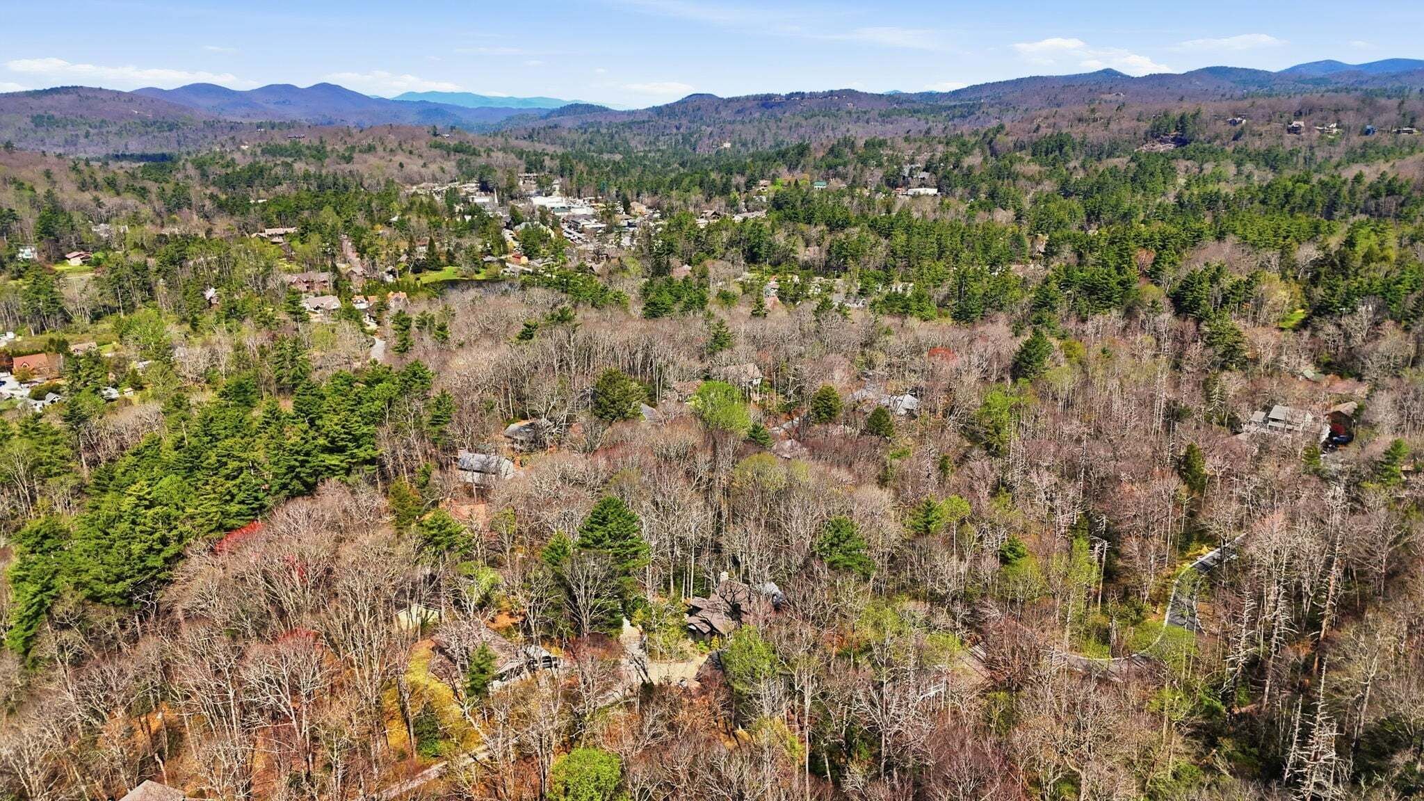 A forested area with scattered buildings, likely a rural or wilderness setting.
