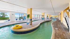 An indoor swimming pool with lounge chairs and a yellow inflatable ring. - Bundle of Three (3) Beachfront Penthouse Suites! Tons Of Resort Amenities! (Myrtle Beach)