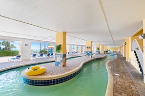 An indoor swimming pool with lounge chairs and a yellow inflatable ring. - Bundle of Two (2) Beachfront Penthouse Suites! Tons Of Resort Amenities! (Myrtle Beach)