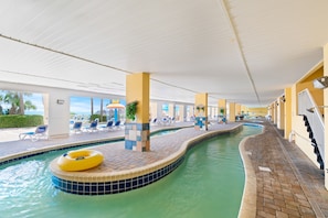 Ein Hallenbad mit Liegestühlen und einem gelben Schwimmreifen.