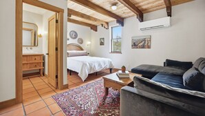 Un dormitorio con cama, armario de madera, mesita de noche, ventana y ventilador de techo.