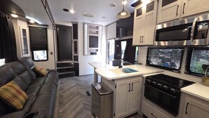 A compact kitchen with a stove, microwave, and a small countertop.