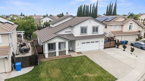 Ein Wohnhaus mit Garage, Solaranlage und einem gepflegten Rasen.