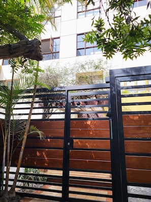 A gated entrance with a wooden fence and a building in the background. - Apartment 3 Bedrooms | 1 block from Larcomar and Marriott (Miraflores)
