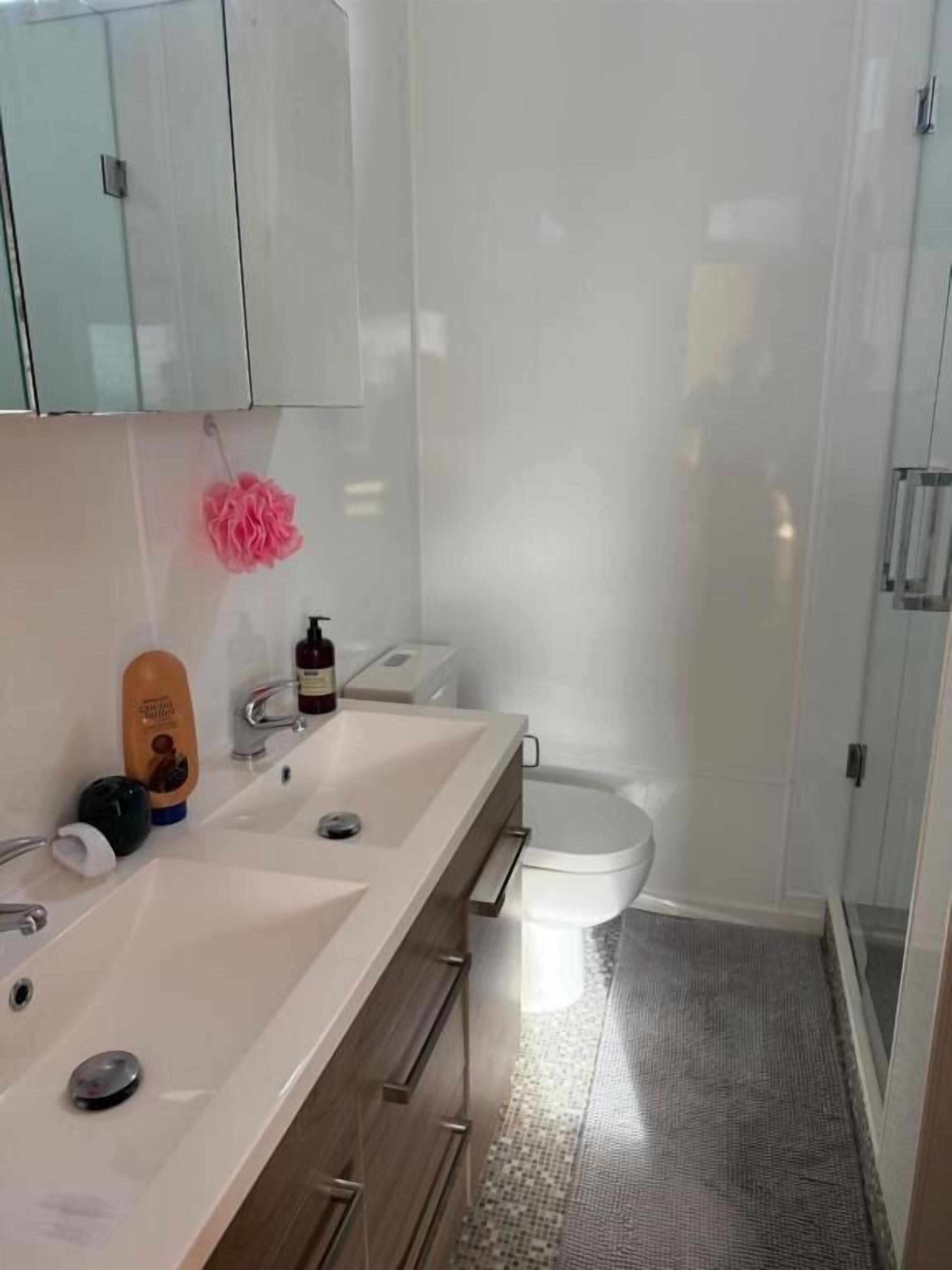 A bathroom with a white sink, a toilet, and a shower area.