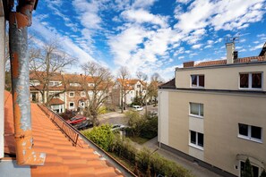 Un quartier résidentiel offrant une vue sur des maisons, un ciel dégagé et un toit recouvert de tuiles rouges.