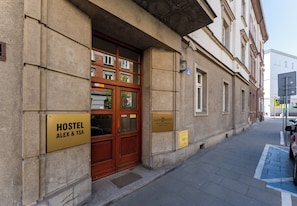 Ein Hostel mit einer Holztür und einem Schild, das 'HOSTEL ALEX & TSA' ausweist.