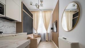 A modern kitchen with a marble countertop, a built-in oven, and a wall-mounted TV. - Tamka Powiśle Superior Studio (Warszawa)