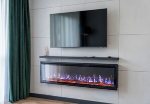 Ein modernes Wohnzimmer mit einem Flachbildfernseher über einem Kamin.