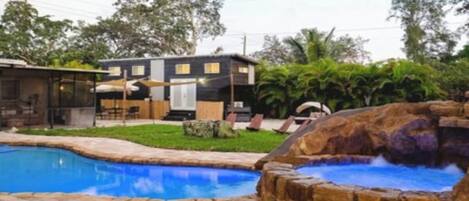 Ein Haus mit Swimmingpool, Whirlpool und einer Terrassenanlage.