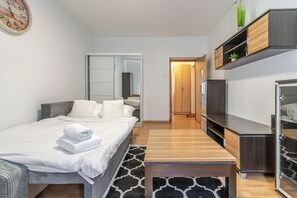 A modern hotel room with a bed, bedside table, wardrobe, and a mirror. - Aleja Przyjaźni Chic Apartment (Gliwice)