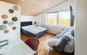 A bedroom with a bed, a desk, a chair, a sofa, a window, and wall decorations. - 4 bedroom cozy home in Allinge (Allinge)