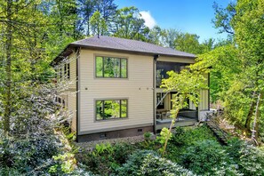 Ein zweigeschossiges Haus mit einer überdachten Veranda und einer kleinen Treppe, die zu einer oberen Ebene führt.