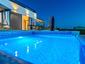 A modern house with a swimming pool at dusk. - Beautiful villa Lara in Vrana with pool by Interhome (Drage)