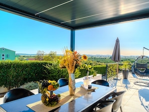 A modern outdoor dining area with a table set for two, a hanging chair, and a view of the countryside. - Beautiful villa Lara in Vrana with pool by Interhome (Drage)