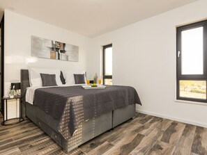 A modern bedroom with a large bed, a side table with a lamp, and a window with a view. - Beautiful villa Lara in Vrana with pool by Interhome (Drage)