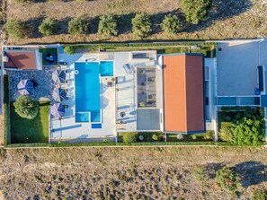 An aerial view of a property with a swimming pool, outdoor seating, and a large building with a red roof. - Beautiful villa Lara in Vrana with pool by Interhome (Drage)