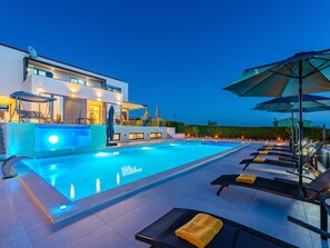 A modern hotel with a swimming pool, sun loungers, and a bar area. - Beautiful villa Lara in Vrana with pool by Interhome (Drage)