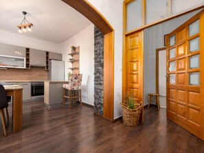 A modern kitchen with a built-in fridge, wooden cabinets, and a stone accent wall. - Apartment Julia A6, 4+2 by Interhome (Biograd na Moru)