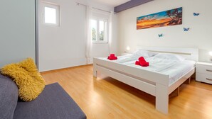 Un dormitorio moderno con cama, mesitas de noche, una ventana y un cuadro en la pared.