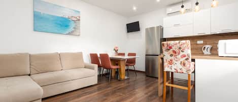 Una cocina moderna con comedor, un sofá y un cuadro en la pared.