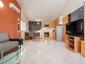 A modern living room with a glass coffee table, a sofa, and a flat-screen TV. - Apartment  by Interhome (Biograd na Moru)