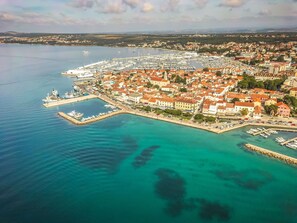 An aerial view of a coastal town with a marina, waterfront buildings, and a clear view of the sea. - Apartment  by Interhome (Biograd na Moru)