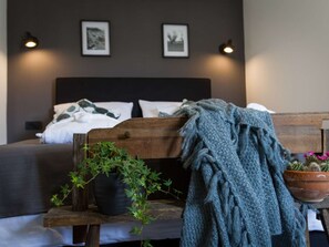 A bedroom with a bed, a bench, a potted plant, and a blanket. - Villa Royal with heated pool by Interhome (Biograd na Moru)