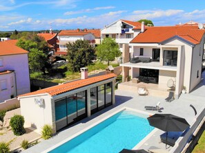 A modern house with a swimming pool, outdoor seating, and a view of neighboring houses. - Villa Magale with a pool by Interhome (Biograd na Moru)