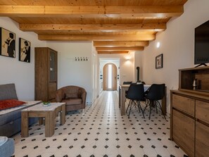 A cozy living room with a sofa, a wooden cabinet, and a dining area with chairs and a table. - Apartment  by Interhome (Ugljan/Ugljan)