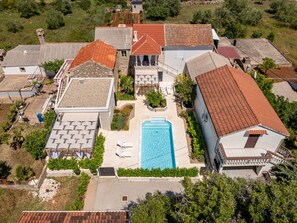 A residential property with a swimming pool, multiple buildings, and a garden area. - Apartment  by Interhome (Ugljan/Ugljan)