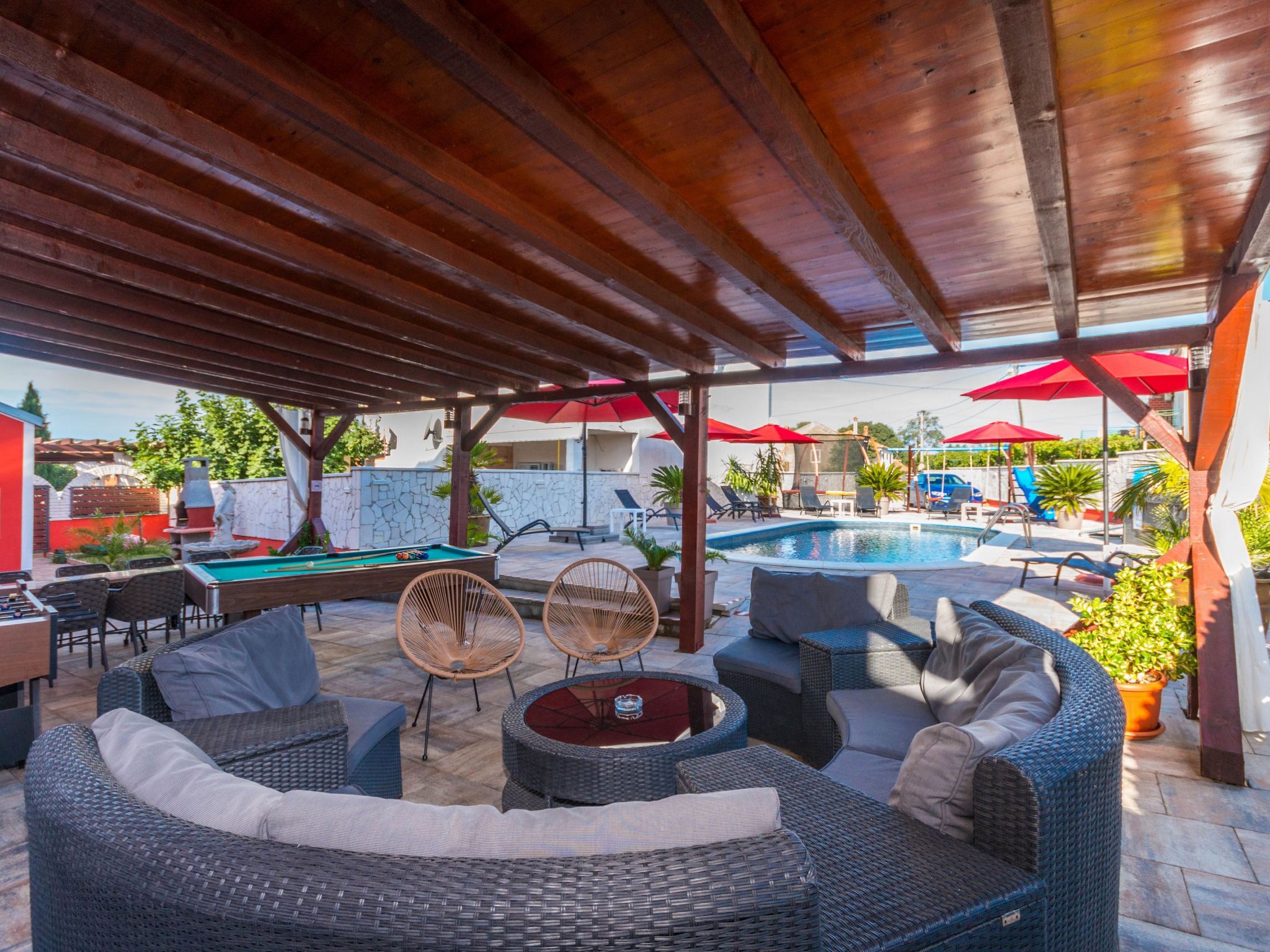 An outdoor pool area with lounge seating and umbrellas.