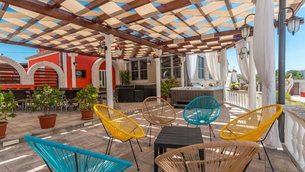 An outdoor patio with a covered seating area, including chairs and tables, and a barbecue grill. - Vacation home  by Interhome (Donje Rastane)