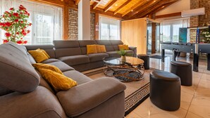 A modern living room with a sectional sofa, a coffee table, and a pool table. - Vacation home  by Interhome (Donje Rastane)