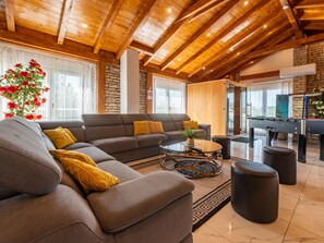 A modern living room with a sectional sofa, a coffee table, and a pool table. - Vacation home  by Interhome (Donje Rastane)