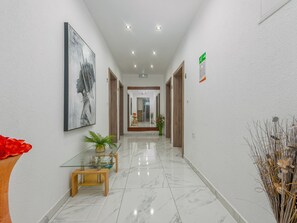 A hallway with a glass table, a plant, and a framed artwork on the wall. - Xxxl Villa Ancora with heated pool by Interhome (Donje Rastane)
