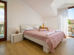 A modern bedroom with a bed, bedside tables, and a view of the outdoors. - Vacation home  by Interhome (Donje Rastane)