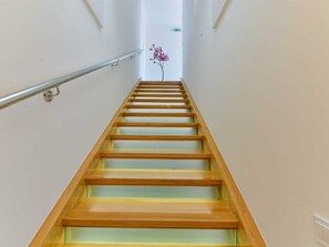 A staircase with wooden steps and a metal handrail, leading upwards. - Apartment  by Interhome (Donje Rastane)