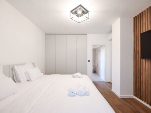 A modern hotel room with a large bed, a wooden accent wall, and a flat-screen TV. - Villa Marta with heated pool and traditional taver by Interhome (Debeljak)