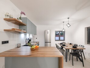 Eine moderne Küche mit einer zentralen Kochinsel, integrierten Geräten und einem Essbereich mit Blick.