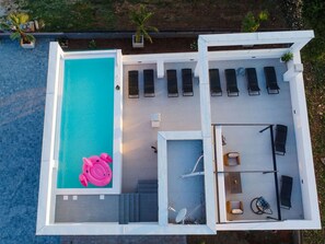 An aerial view of a modern pool area with a large pool, sun loungers, a small seating area, and a pink inflatable toy. - Villa La Perla Apt 4, 4+2 with heated rooftop pool by Interhome (Zadar/Bibinje)