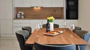 Eine moderne Küche mit weißen Schränken, einer Holz Arbeitsplatte und einem eingebauten Backofen.