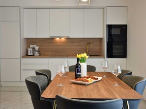 A modern kitchen with white cabinets, a wooden countertop, and a built-in oven. - Apartment  by Interhome (Zadar/Bibinje)
