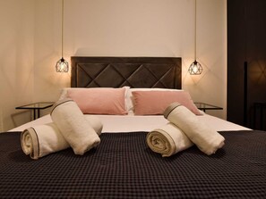 A neatly made bed with pillows and rolled towels, two bedside tables with lamps, and a dark headboard. - Villa La Perla Apt 4, 4+2 with heated rooftop pool by Interhome (Zadar/Bibinje)