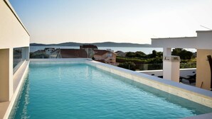 Ein Dachpool mit Blick auf das Meer und die umliegenden Gebäude.